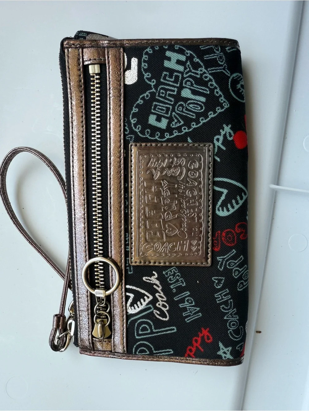 Coach Black Poppy Graffiti Print Wristlet with Bronze Trim and Red Accents